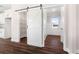 Pantry with custom shelving and rolling barn door with dark hardwood floors at 1874 Mcgarity Rd, Mcdonough, GA 30252