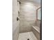 Tiled walk-in shower with bench, stone tile and mosaic floors at 1874 Mcgarity Rd, Mcdonough, GA 30252