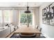 Dining room features a modern pendant light fixture over a wood table and contemporary art on the wall at 2167 Crestridge Ne Trl, Brookhaven, GA 30329