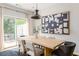 Dining room with wooden table, modern light fixture, and view of the outdoor patio through sliding doors at 2167 Crestridge Ne Trl, Brookhaven, GA 30329