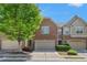Charming brick townhome featuring a two-car garage and manicured landscaping under a sunny sky at 2167 Crestridge Ne Trl, Brookhaven, GA 30329