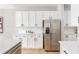 Modern kitchen featuring white cabinets, stainless steel refrigerator, and stylish subway tile backsplash at 2167 Crestridge Ne Trl, Brookhaven, GA 30329