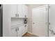 Mudroom with white cabinets and countertop, subway tile, and exterior door to side yard at 2167 Crestridge Ne Trl, Brookhaven, GA 30329