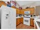 Bright kitchen with white appliances, wood cabinets, and wood-look flooring at 1078 Camry Cir, Dallas, GA 30157