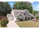 Charming two-story home with lush green lawn, flowering shrubs, and a two car garage at 124 Grand Oaks Dr, Canton, GA 30115