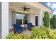 Inviting front porch with comfortable seating, ceiling fan, decorative pillars, and beautiful landscaping at 124 Grand Oaks Dr, Canton, GA 30115