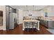 Well-lit kitchen featuring stainless steel appliances, center island, and hardwood flooring at 124 Grand Oaks Dr, Canton, GA 30115