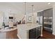 Open kitchen with a granite island, stainless appliances, hardwood floors, and a view of the living area at 124 Grand Oaks Dr, Canton, GA 30115