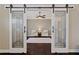 Elegant living room is showcased beyond sliding barn doors, with hardwood floors, and a seating area at 124 Grand Oaks Dr, Canton, GA 30115