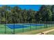 The community tennis court with blue and green surface, surrounded by black fence and trees on a sunny day at 124 Grand Oaks Dr, Canton, GA 30115