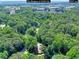 Aerial view of a wooded area with houses nearby and a road running through the trees at 1379 Branchwood Dr, Snellville, GA 30078