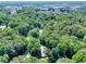 Aerial view of a wooded area with houses nearby and a road running through the trees at 1379 Branchwood Dr, Snellville, GA 30078