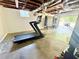 Unfinished basement space with a treadmill and access to the garage and backyard at 2771 Stonecreek Se Rd, Smyrna, GA 30080