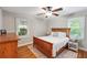 Cozy bedroom with a wooden bed frame, hardwood floors, and natural light from two windows at 2771 Stonecreek Se Rd, Smyrna, GA 30080