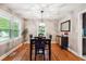 Elegant dining room featuring hardwood floors, a modern light fixture, and a stylish cabinet with decor at 2771 Stonecreek Se Rd, Smyrna, GA 30080