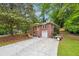 Charming brick home with a lush front yard, a driveway, mature trees, and a cozy front porch at 2771 Stonecreek Se Rd, Smyrna, GA 30080