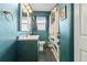 Stylish bathroom with vibrant teal walls, unique patterned floors, and modern fixtures at 3967 Manson Se Ave, Smyrna, GA 30082