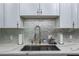 Stylish kitchen sink features white countertops, mosaic backsplash, and chrome fixtures at 2865 Lenox Ne Rd # 211, Atlanta, GA 30324