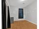 An empty bedroom with wood laminate flooring, a window, and black curtains at 902 Allene Sw Ave, Atlanta, GA 30310