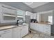 Bright kitchen with a double sink, white cabinets, and view into another room at 902 Allene Sw Ave, Atlanta, GA 30310