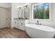 Modern bathroom with a soaking tub next to a large window, double vanity and stylish fixtures at Lot 1 Perkins Rd, Dallas, GA 30157