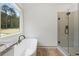 Modern bathroom featuring a soaking tub beside a window and a glass enclosed shower at Lot 1 Perkins Rd, Dallas, GA 30157