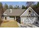 Charming single-Gathering home featuring a two-car garage, stone accents, a gabled roof, and lush greenery at Lot 1 Perkins Rd, Dallas, GA 30157