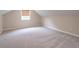 View of the attic featuring neutral walls, carpet, and a window with a blind at 1555 New Ne St, Atlanta, GA 30307