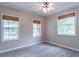 Bright bedroom featuring hardwood floors, ceiling fan, and natural light from three windows with woven blinds at 1555 New Ne St, Atlanta, GA 30307