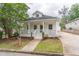 Craftsman home boasts a large front porch, walkway, and a long driveway leading to a detached garage at 1555 New Ne St, Atlanta, GA 30307