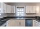 Modern kitchen with stainless steel appliances, white cabinets, and dark granite countertops at 1555 New Ne St, Atlanta, GA 30307