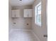 Bright laundry room with white cabinets, tile flooring, and a window at 1555 New Ne St, Atlanta, GA 30307