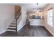 Open-concept living space with hardwood flooring, staircase, and view into kitchen at 1555 New Ne St, Atlanta, GA 30307