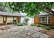 Charming backyard featuring a stone patio, lush greenery, covered grilling area, and inviting ambiance at 1798 Melrose Sw Dr, Atlanta, GA 30310