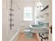 Charming bathroom featuring vintage blue fixtures, white tiling, and a window for natural light at 1798 Melrose Sw Dr, Atlanta, GA 30310