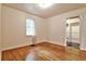Bright bedroom with hardwood floors, a window with natural light, and a doorway leading to an ensuite at 1798 Melrose Sw Dr, Atlanta, GA 30310
