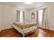 Bedroom featuring hardwood floors, two windows, and vintage-style bed frame at 1798 Melrose Sw Dr, Atlanta, GA 30310