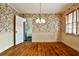Charming dining room featuring floral wallpaper, hardwood floors, and modern lighting fixture at 1798 Melrose Sw Dr, Atlanta, GA 30310