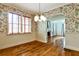 Elegant dining room with floral wallpaper, hardwood floors, and decorative lighting at 1798 Melrose Sw Dr, Atlanta, GA 30310