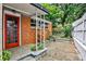Charming red brick home exterior with a red door and landscaped stone patio at 1798 Melrose Sw Dr, Atlanta, GA 30310