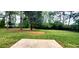 Expansive backyard featuring lush green grass, mature trees, and a concrete patio at 60 Whispering Pine Ct, Covington, GA 30016