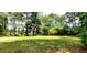 Large grassy backyard surrounded by mature trees at 60 Whispering Pine Ct, Covington, GA 30016