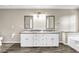 Modern bathroom with double vanities, marble countertops, and wood grain floors at 60 Whispering Pine Ct, Covington, GA 30016