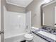 Well-lit bathroom featuring a tub, toilet, and marble-topped vanity with sink and a large mirror at 60 Whispering Pine Ct, Covington, GA 30016