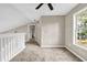 Cozy upstairs bedroom with ceiling fan, soft carpet, and large window overlooking trees and railing at 60 Whispering Pine Ct, Covington, GA 30016