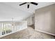 Bright upstairs bedroom with ceiling fan, soft carpet, and large window overlooking trees and railing at 60 Whispering Pine Ct, Covington, GA 30016