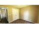 Bedroom features neutral carpeting and paint and a closet with bi-fold doors at 60 Whispering Pine Ct, Covington, GA 30016