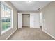 A cozy bedroom features neutral walls, plush carpet, and a bright window offering natural light and backyard views at 60 Whispering Pine Ct, Covington, GA 30016