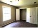 Inviting bedroom with carpet, neutral walls, bright window, and a closet with bi-fold doors at 60 Whispering Pine Ct, Covington, GA 30016