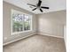 Bright bedroom with ceiling fan, soft carpet, and large window overlooking trees at 60 Whispering Pine Ct, Covington, GA 30016